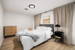 a white bedroom with a large bed and a dresser at The Silo 5- 1 BD Urban Haven in Morton
