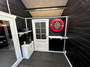 a garage with a door and a dart board on the wall at Rural Retreat with Hot Tub, Fire Pit & Games Room in Sheffield