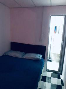 a bedroom with a blue bed and a window at Peró Beach Hospedaria in Cabo Frio