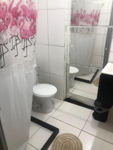 a bathroom with a toilet and a shower at Peró Beach Hospedaria in Cabo Frio