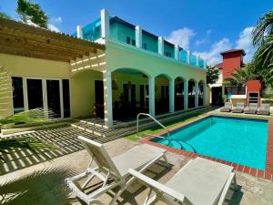 una villa con piscina y una casa en Private 7BR Luxury Villa and Pool walk to Palm Beach, en Palm-Eagle Beach