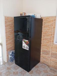 a black refrigerator in front of a brick wall at Baafeh Beach in Sanyang