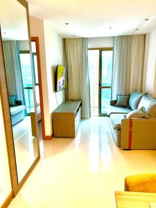 een woonkamer met een bank en een spiegel bij Flat completo próximo ao Rio centro e Arena Carioca in Rio de Janeiro