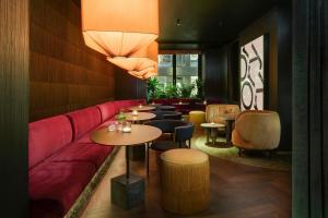 a restaurant with a red couch and tables and chairs at Mandarin Oriental, Munich in Munich