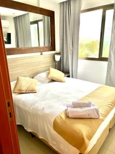 een slaapkamer met een bed met twee handdoeken erop bij Flat completo próximo ao Rio centro e Arena Carioca in Rio de Janeiro