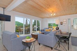 a living room with two couches and a table at Twin Lake Retreat - Hot Tub & Private Beach in L'Ange-Gardien