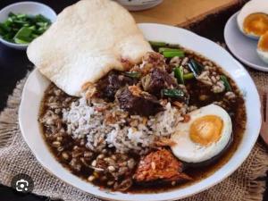 a bowl of food with rice and an egg on top at JALA GUEST HOUSE near JUANDA AIRPORT in Sawotratap