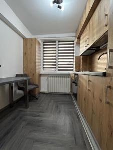 an empty kitchen with a table and a window at Azure Apartment in Craiova