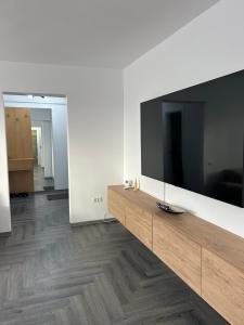 a living room with a large flat screen tv on a wall at Azure Apartment in Craiova