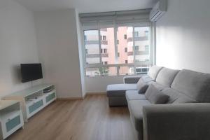 a living room with a couch and a tv at Estudio Pastora in Torremolinos