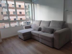 a couch in a living room with a large window at Estudio Pastora in Torremolinos