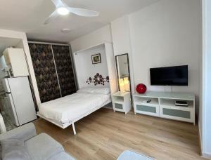 a living room with a couch and a flat screen tv at Estudio Pastora in Torremolinos +13 photos