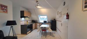 a small kitchen with a table and a refrigerator at Location, 10 mn des plages. in Saint-Coulomb
