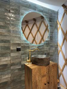 a bathroom with a sink and a mirror at Jurta nad Zegrzem z prywatnym jacuzzi in Arciechow