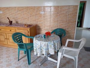 a table with two chairs and a table with a vase on it at Baafeh Beach in Sanyang