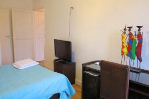um quarto com uma cama e uma secretária com uma televisão em Viva Riviera - 10 Rue Commandant André em Cannes