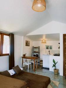 a living room with a table and a kitchen at Bloom Siargao - Cozy Villa in Pacifico in San Isidro