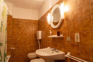 a bathroom with a sink and a toilet and a mirror at Casa il Rio in Riolunato +15 photos