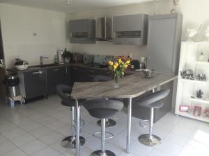 una cucina con un tavolo con un vaso di fiori sopra di Chambre avec vue chez l'habitant a Saint Pierre en Faucigny