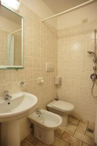 a bathroom with a sink and a toilet and a mirror at Albergo La Rocca in Assisi