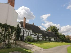 an old black and white house with a thatched roof at Rose Cottage in Stratford-upon-Avon