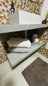a bathroom with a sink and towels on a shelf at JanHouse Ilhabela in Ilhabela +27 photos