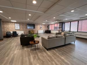 a lobby with couches and chairs in a building at Hydrogen in Nottingham in Nottingham