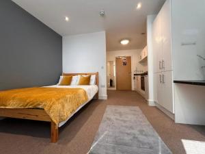 a bedroom with a large bed and a kitchen at Hydrogen in Nottingham in Nottingham