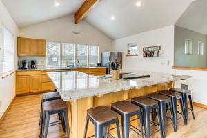 a kitchen with a large island with bar stools at Rockaway Beach Home with Hot Tub 4 Blocks to Beach! in Rockaway Beach