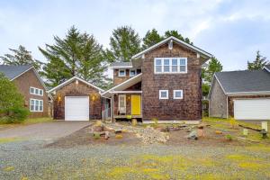a brick house with a garage in front of it at Rockaway Beach Home with Hot Tub 4 Blocks to Beach! in Rockaway Beach
