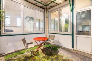 a red table and chairs in a room with windows at Joli - Lovely studio Paris in Paris +15 photos