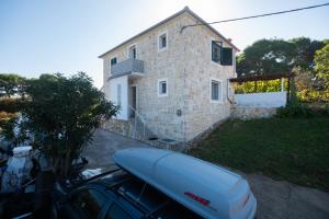 a house with a car parked in front of it at MY DALMATIA - Sea view holiday home Antonela in Dobropoljana
