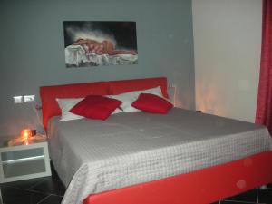 een rood bed met rode kussens in een slaapkamer bij House Volumnia in Perugia