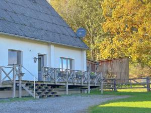 a house with a wooden deck next to a fence at Landhaus Landgelück in Hellenthal