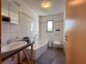 a bathroom with a tub and a sink and a toilet at Landhaus Landgelück in Hellenthal +23 photos