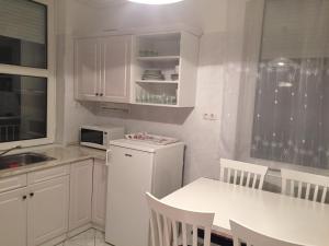 ヘーヴィーズにあるYuliya 9の白いキッチン(テーブル、白い冷蔵庫付)