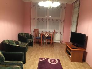 - un salon avec une table, des chaises et une télévision dans l'établissement Yuliya 9, à Hévíz