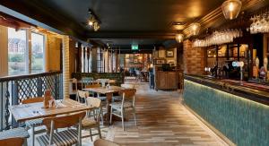 a restaurant with tables and chairs and a bar at The Boathouse Inn & Riverside Rooms in Chester