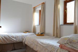 a bedroom with two beds and a mirror at Apple Cottage in Stokeinteignhead