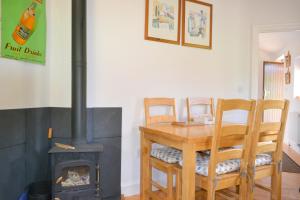 a kitchen with a wood stove and a table and chairs at Apple Cottage in Stokeinteignhead