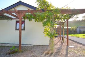 a pergola with trees in front of a house at Apple Cottage in Stokeinteignhead