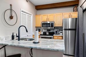 a kitchen with a granite counter top and a stainless steel refrigerator at Laurelwood 44 with Wintergreen Advantage in Wintergreen