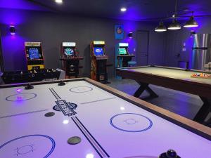 a room with a pool table and arcade machines at Yosemite Country House sleeps 20 w/ hot tub, firepit, bonus studio! in Ahwahnee
