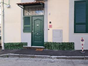 a green door on the side of a building at La Petite Maison in Naples