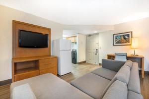 a living room with a couch and a flat screen tv at Tropical Winds Resort Hotel in Daytona Beach