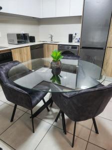 a glass table with a potted plant on it in a kitchen at Cozy home in Pretoria +3 photos