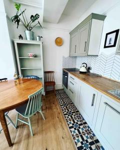 a kitchen with white cabinets and a wooden table at Seashell Apartment - Central location in Folkestone +40 photos