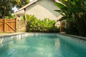 ein Swimmingpool vor einem Haus in der Unterkunft Villa Trembesi in Kuta Lombok