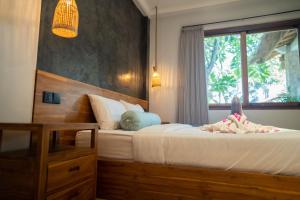 ein Schlafzimmer mit zwei Betten und einem Fenster in der Unterkunft Villa Trembesi in Kuta Lombok + 30 Fotos