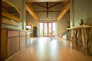 ein Wohnzimmer mit Holzböden und einem großen Fenster in der Unterkunft Villa Trembesi in Kuta Lombok